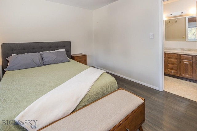 bedroom featuring baseboards, dark wood-type flooring, and ensuite bathroom