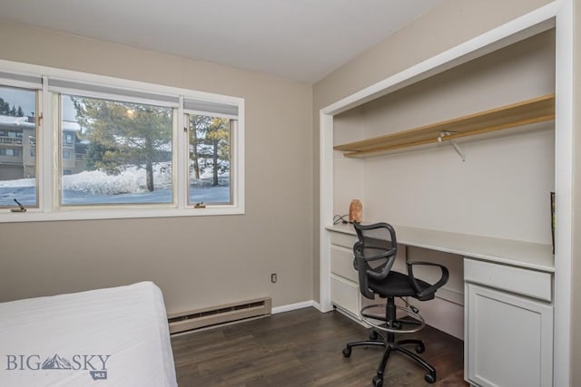 home office with a baseboard heating unit, baseboards, dark wood-style floors, and built in study area