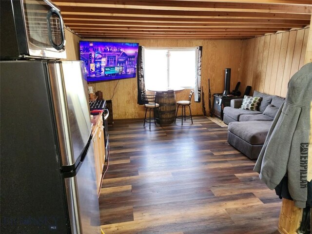 living area with wooden walls and wood finished floors