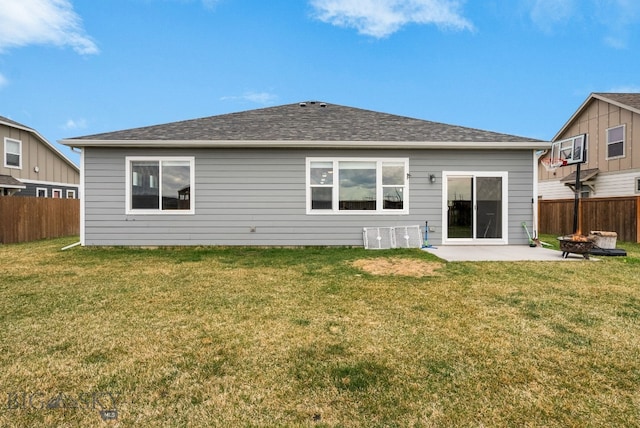 back of house featuring fence, a lawn, an outdoor fire pit, and a patio
