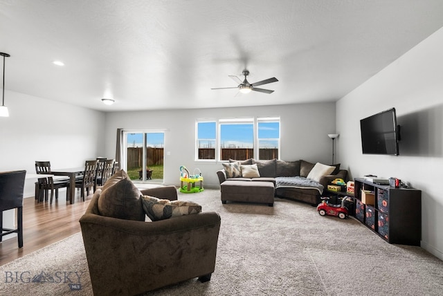 living area featuring a ceiling fan and baseboards