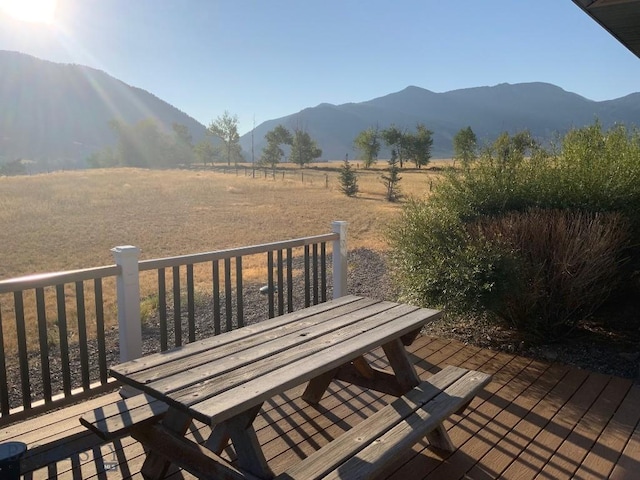 36 Rowdy Way, Ennis, MT 59729 - wooden deck with outdoor dining space, a view of countryside, and a mountain view
