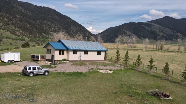 36 Rowdy Way, Ennis, MT 59729 - view of front of home with a deck with mountain view, a front yard, metal roof, and a view of rural / pastoral area