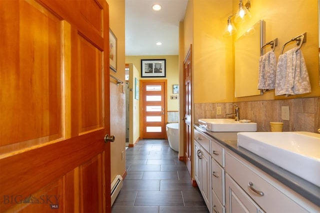 175 Vandyke Rd, Bozeman, MT 59718 - bathroom featuring a baseboard radiator, double vanity, a freestanding tub, tile patterned flooring, and recessed lighting