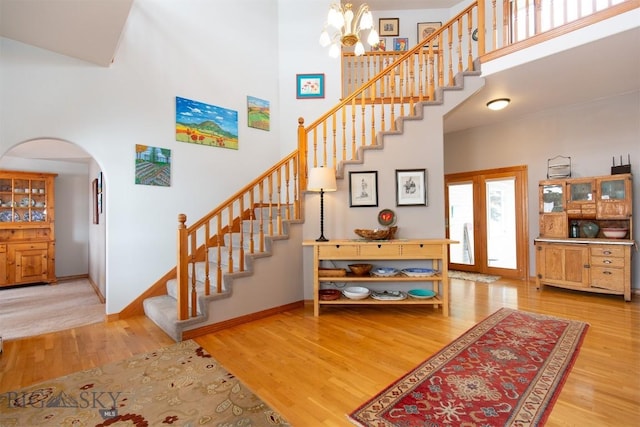 175 Vandyke Rd, Bozeman, MT 59718 - stairs with a high ceiling, arched walkways, wood finished floors, a chandelier, and baseboards