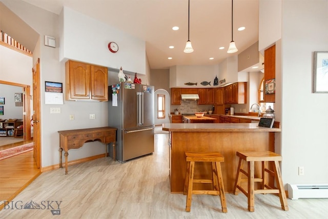 175 Vandyke Rd, Bozeman, MT 59718 - kitchen featuring high end fridge, baseboard heating, a peninsula, under cabinet range hood, and light wood finished floors