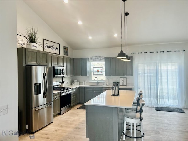 42 Wild Rye Pl, Three Forks, MT 59752 - kitchen featuring stainless steel appliances, vaulted ceiling, light countertops, a breakfast bar area, and pendant lighting