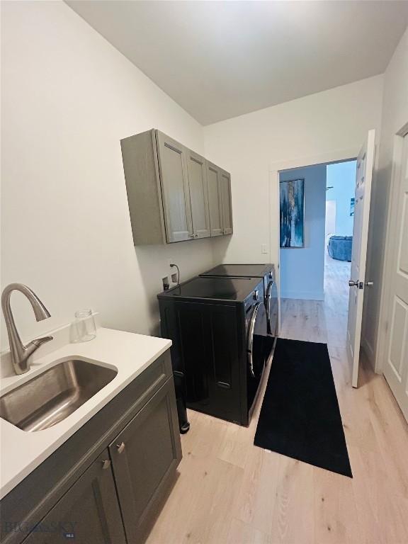 42 Wild Rye Pl, Three Forks, MT 59752 - laundry room with cabinet space, light wood-type flooring, and washer and clothes dryer