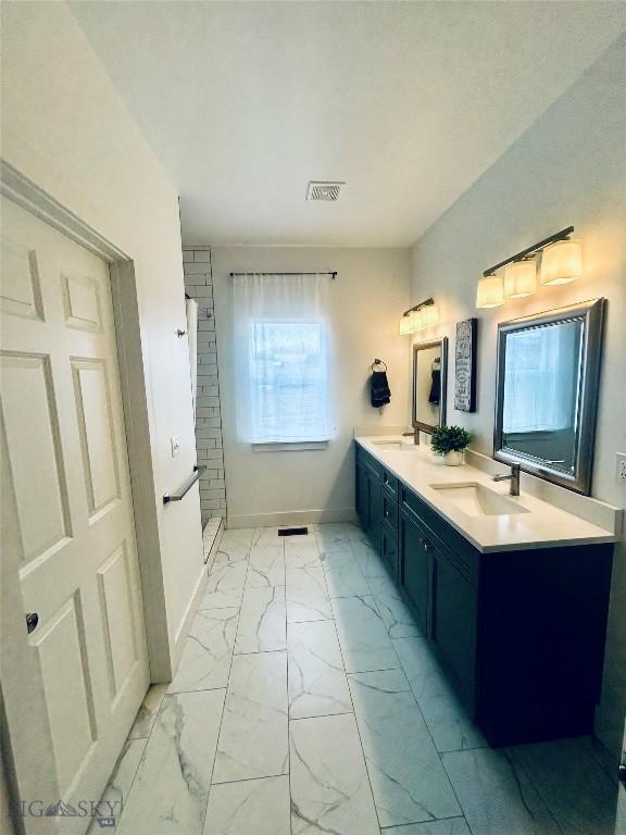 42 Wild Rye Pl, Three Forks, MT 59752 - bathroom featuring marble look tile flooring, double vanity, and a shower