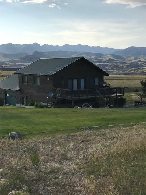37 Bridger Meadow Ln, Emigrant, MT 59065 - rear view of property featuring a deck with mountain view, stairs, a yard, and metal roof