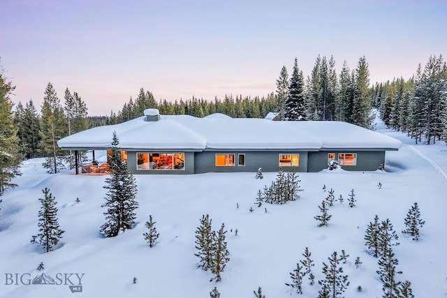 214 W Pine Cone Ter, Big Sky, MT 59716 - snow covered rear of property with a forest view