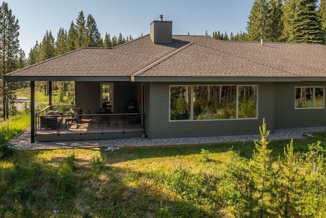 214 W Pine Cone Ter, Big Sky, MT 59716 - rear view of property with a chimney, a yard, and a shingled roof