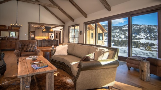 11310 Taiga Trl, Bozeman, MT 59715 - living room featuring beam ceiling, high vaulted ceiling, a mountain view, wood finished floors, and a chandelier