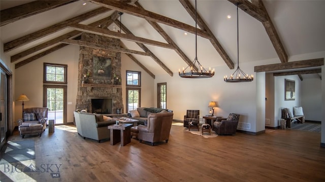 11310 Taiga Trl, Bozeman, MT 59715 - living room featuring a chandelier, high vaulted ceiling, beam ceiling, wood finished floors, and a stone fireplace