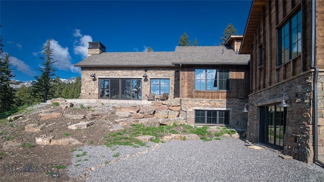 11310 Taiga Trl, Bozeman, MT 59715 - back of property featuring stone siding, a chimney, roof with shingles, and board and batten siding