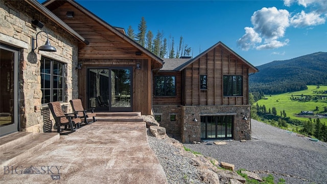 11310 Taiga Trl, Bozeman, MT 59715 - view of exterior entry featuring stone siding and a mountain view