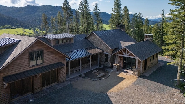 11310 Taiga Trl, Bozeman, MT 59715 - view of front of property with a standing seam roof, a metal roof, a mountain view, and a shingled roof