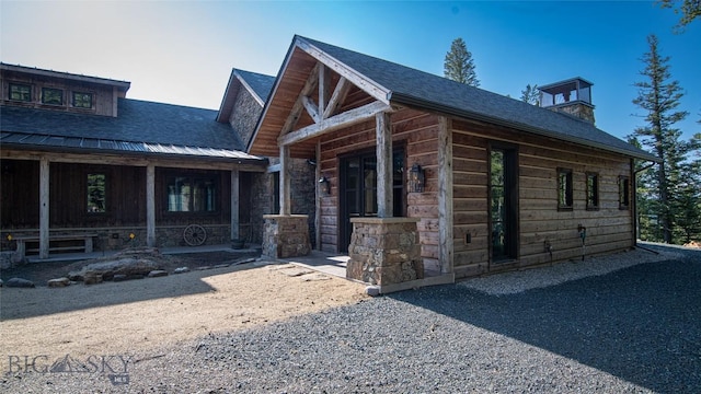 11310 Taiga Trl, Bozeman, MT 59715 - view of front of property with a shingled roof, a chimney, and covered porch