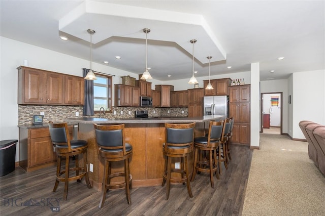 590 Coyote Ln, Butte, MT 59701 - kitchen with appliances with stainless steel finishes, tasteful backsplash, a kitchen breakfast bar, dark countertops, and recessed lighting