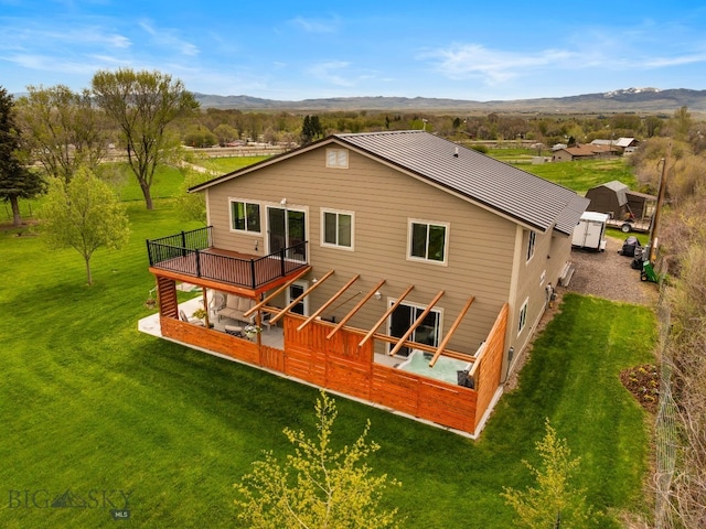 247 Clarks Lookout Rd, Dillon, MT 59725 - back of property with a deck with mountain view and a lawn