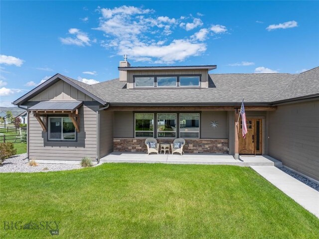154 Nellie Ct, Manhattan, MT 59741 - rear view of property featuring a lawn, board and batten siding, stone siding, a shingled roof, and a chimney
