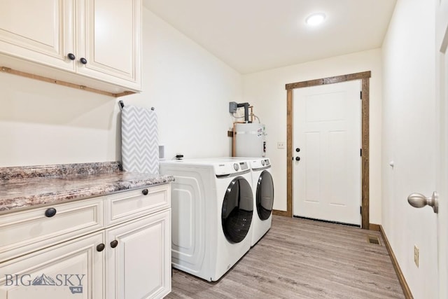 83 Sky Vw, Ennis, MT 59729 - laundry area with strapped water heater, washing machine and dryer, light wood finished floors, cabinet space, and baseboards