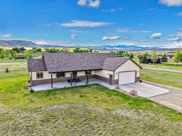 83 Sky Vw, Ennis, MT 59729 - ranch-style home featuring a porch, concrete driveway, a mountain view, an attached garage, and a front lawn