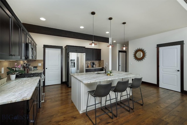 4156 Sunstone St, Bozeman, MT 59718 - kitchen featuring stainless steel appliances, a breakfast bar, dark wood finished floors, a sink, and light stone countertops