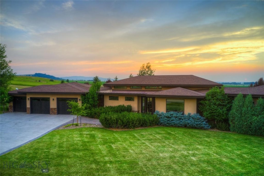 231 Derek, Bozeman, MT 59718 - view of front of property with a front yard, driveway, stucco siding, and an attached garage