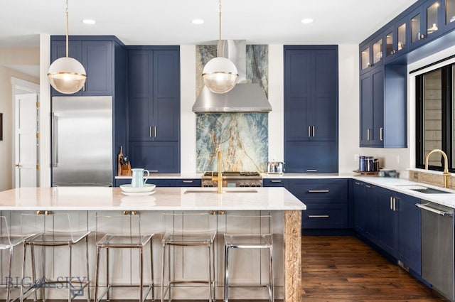 676 Tillyfour, Bozeman, MT 59718 - kitchen with stainless steel appliances, range hood, blue cabinets, decorative backsplash, and dark wood-type flooring