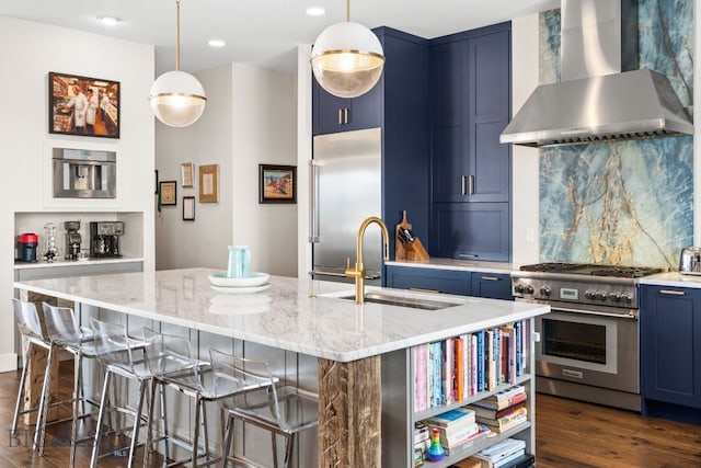 676 Tillyfour, Bozeman, MT 59718 - kitchen featuring premium appliances, wall chimney range hood, blue cabinets, a breakfast bar area, and decorative backsplash