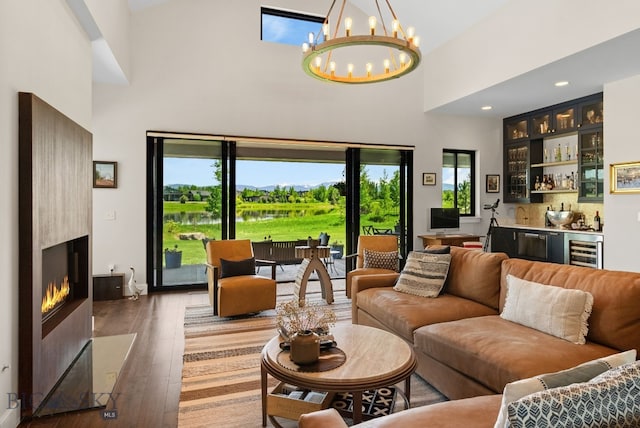 676 Tillyfour, Bozeman, MT 59718 - living area featuring a towering ceiling, wet bar, beverage cooler, a large fireplace, and hardwood / wood-style flooring