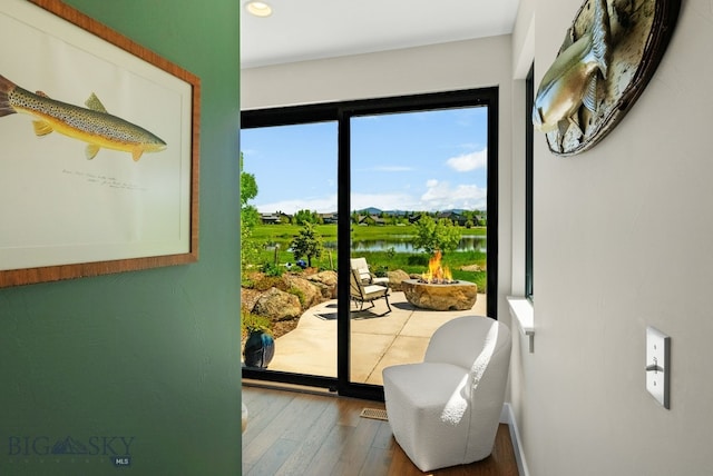 676 Tillyfour, Bozeman, MT 59718 - doorway to outside with wood-type flooring, a water view, and recessed lighting