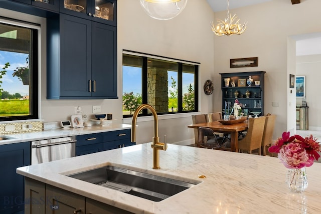 676 Tillyfour, Bozeman, MT 59718 - kitchen featuring light stone countertops, glass insert cabinets, stainless steel dishwasher, decorative light fixtures, and a chandelier