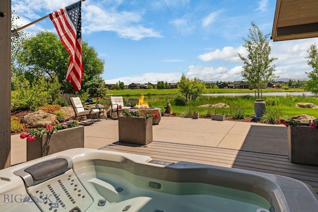 676 Tillyfour, Bozeman, MT 59718 - view of patio / terrace with an outdoor hot tub, a water view, and a fire pit
