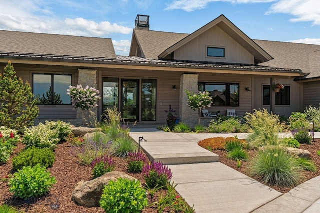 676 Tillyfour, Bozeman, MT 59718 - rear view of property with a standing seam roof, a porch, a shingled roof, a metal roof, and a chimney