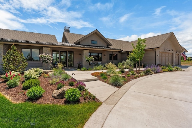 676 Tillyfour, Bozeman, MT 59718 - view of front facade featuring a chimney, an attached garage, driveway, and roof with shingles