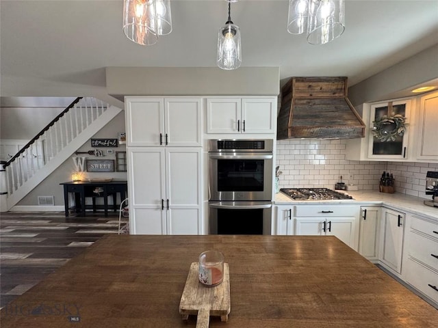 23 Indian Rings Rd, Big Timber, MT 59011 - kitchen featuring stainless steel appliances, custom exhaust hood, tasteful backsplash, and white cabinetry