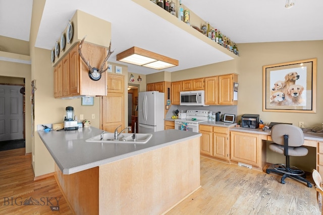 3310 Tumbleweed Dr, Bozeman, MT 59715 - kitchen featuring a peninsula, white appliances, light wood-style floors, light countertops, and a sink