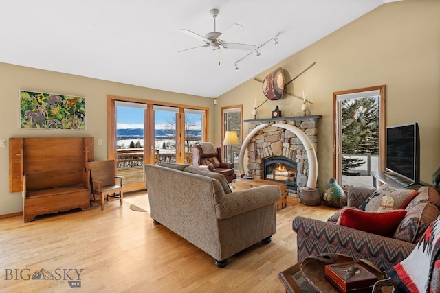 3310 Tumbleweed Dr, Bozeman, MT 59715 - living area featuring a ceiling fan, a fireplace, rail lighting, high vaulted ceiling, and light wood-style flooring