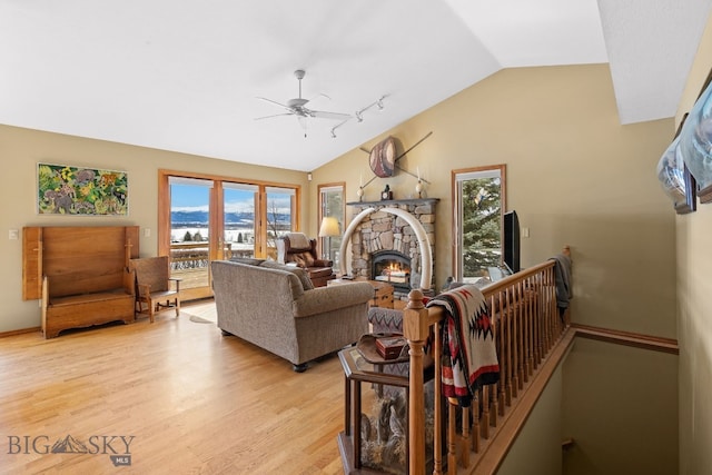 3310 Tumbleweed Dr, Bozeman, MT 59715 - living area with a fireplace, light wood-style floors, baseboards, ceiling fan, and vaulted ceiling