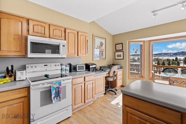 3310 Tumbleweed Dr, Bozeman, MT 59715 - kitchen with built in desk, light wood finished floors, white appliances, lofted ceiling, and a mountain view
