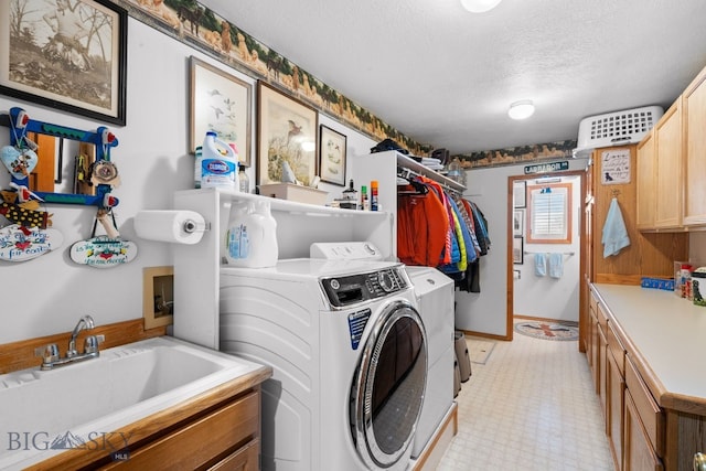3310 Tumbleweed Dr, Bozeman, MT 59715 - laundry area with washer and dryer, baseboards, a textured ceiling, a sink, and cabinet space