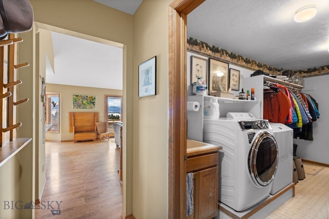 3310 Tumbleweed Dr, Bozeman, MT 59715 - laundry area with laundry area, light wood-style floors, baseboards, a textured ceiling, and washing machine and clothes dryer