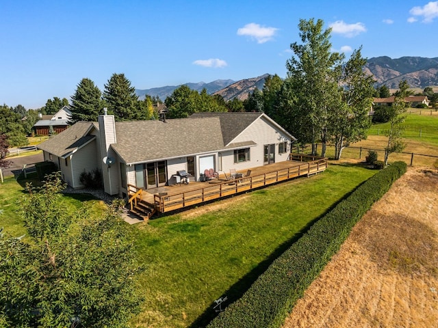 3310 Tumbleweed Dr, Bozeman, MT 59715 - rear view of property with fence, roof with shingles, a deck with mountain view, a chimney, and a lawn