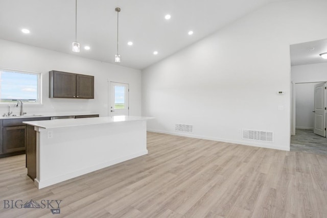 6 S Durango Trl, Three Forks, MT 59752 - kitchen featuring light countertops, a kitchen island, light wood finished floors, recessed lighting, and dark brown cabinets