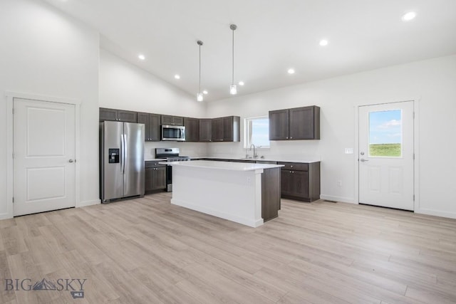 5 S Durango Trl, Three Forks, MT 59752 - kitchen featuring appliances with stainless steel finishes, dark brown cabinetry, light countertops, a center island, and light wood-style floors