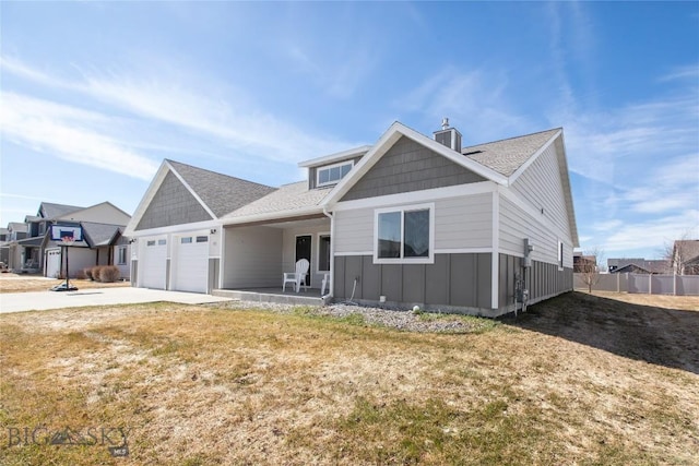 121 Scott Dr, Bozeman, MT 59718 - view of front facade with board and batten siding, an attached garage, a chimney, driveway, and a shingled roof