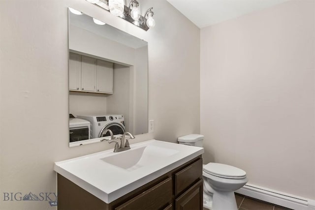 510 Flathead Ave, Bozeman, MT 59715 - bathroom featuring a baseboard radiator, washer and clothes dryer, toilet, vanity, and tile patterned flooring