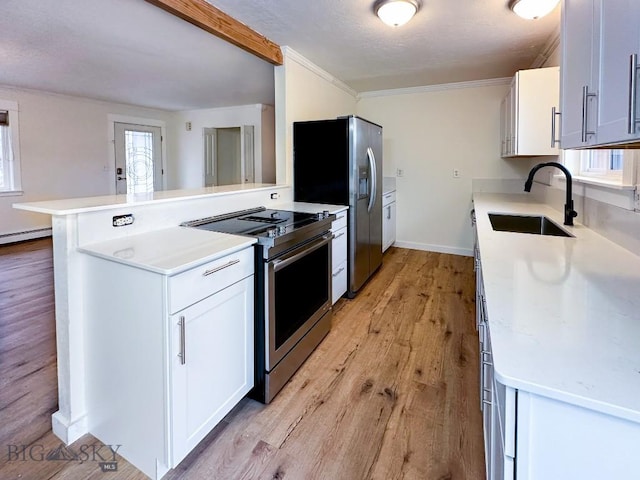 510 Flathead Ave, Bozeman, MT 59715 - kitchen with stainless steel appliances, a sink, light wood finished floors, light countertops, and a peninsula